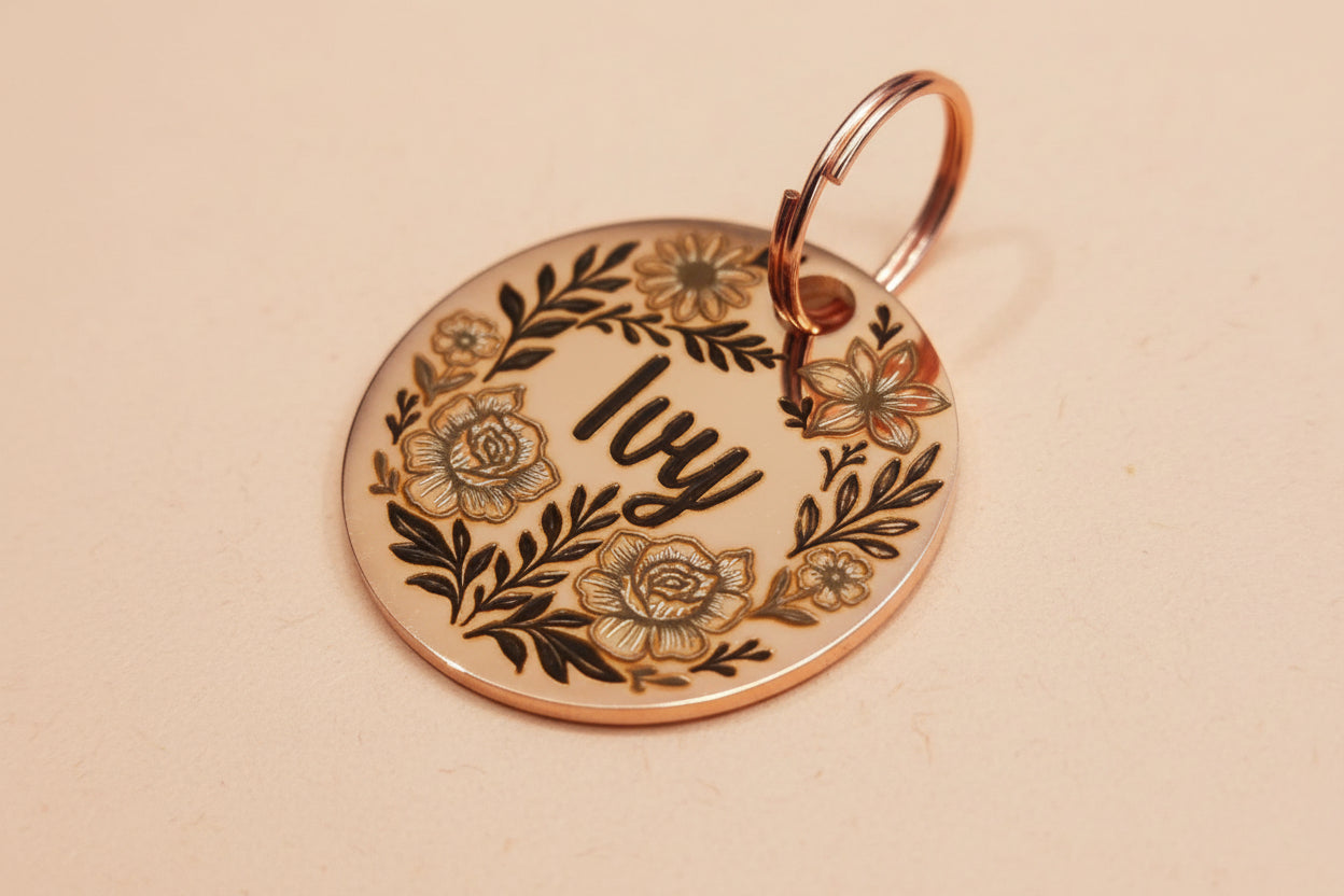 Rose gold dog tag with floral designs and 'Ivy' engraved of the surface